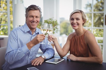 Couple toasting glasses of wine in restaurant