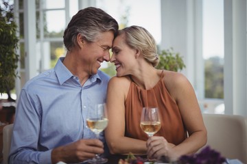 Couple interacting while having wine in restaurant