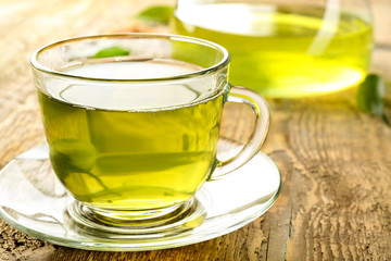 Cup of green tea on wooden table