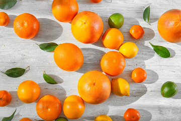 Appetizing fresh citrus fruits on white wooden background