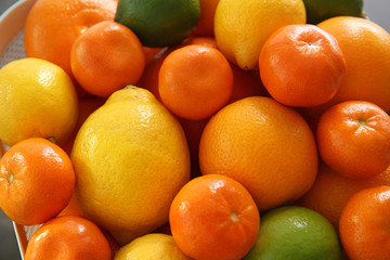 Fresh juicy citrus fruits in basket, closeup