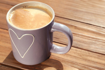 Cup with delicious coffee on wooden window sill