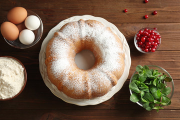 Plate with delicious freshly baked cake on wooden table