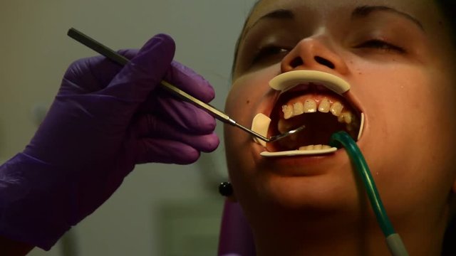the dentist checks the patient's bite with dental mirror 