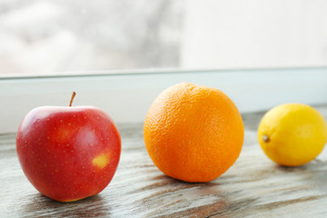 Apple, orange and lemon on windowsill
