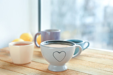 Fototapeta na wymiar Four cups with hot coffee on windowsill