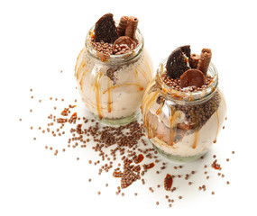 Delicious parfait with chocolate in jars on white background
