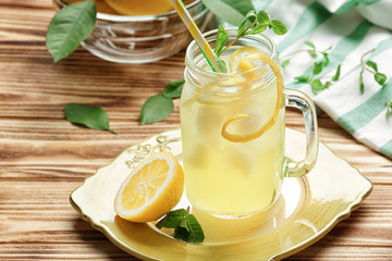 Obraz na płótnie Canvas Delicious lemon juice in mason jar on wooden table