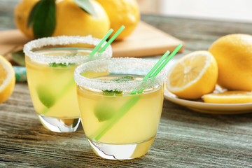 Glasses of lemon juice on wooden table