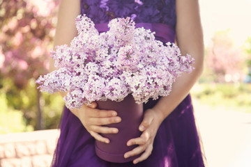Young girl holding beautiful bouquet in hands, outdoors