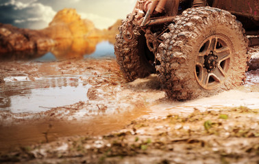 Off road vehicle coming out of a mud hole hazard,Travel and racing concept for four wheel drive off road vehicle . © chokchaipoo