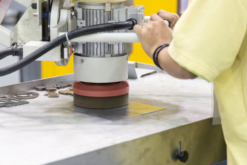 The worker polishing the metal plate for prepare surface.