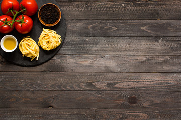 Tagliatelle with tomato and basil, made at home, on a wooden background.