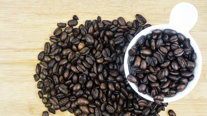 coffee beans in white cup on wooden background