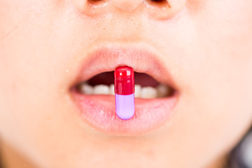 Naklejka premium drug capsule on woman mouth