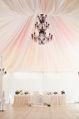 Marquee for the celebration of the wedding. Beautiful white interior with white draperies