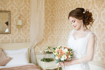Pretty young Bride. Boudoir morning of the bride. Looking on her bouquet