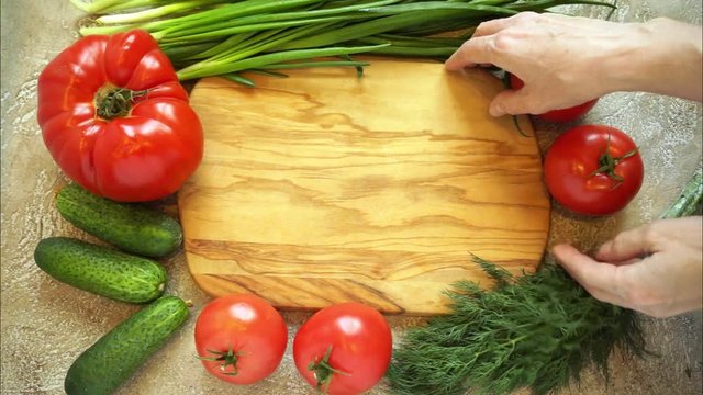 hands made a frame from vegetables around the cutting board, then remove the board and then remains the food background with copy space for your text