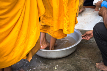 Queue of barefoot monks with foot wash ceremonial in south of Vietnam