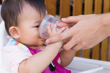  Mother feeding soup water for young kid eight month at home.