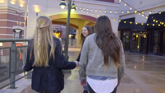 Carefree Teens Dance And Walk Around Outdoor Shopping Mall At Night 