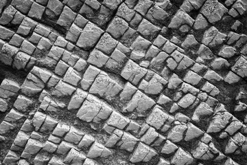Close-up of a bizarre rock surface texture with vignetting in black&white.