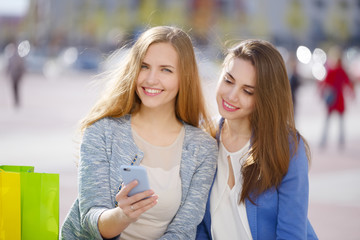 Two stylish girls with shopping bags