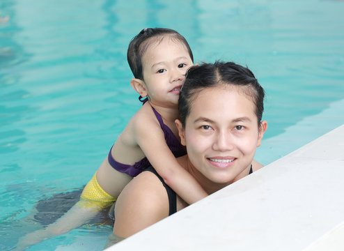 Portrait of mother and little girl in swimming pool.