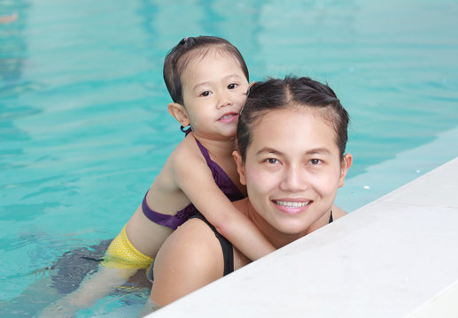 Portrait of mother and little girl in swimming pool.