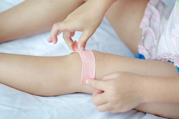 Close Up of child knee with a plaster (for wounds), Selective focus at bandage. Health care and medicine concept.