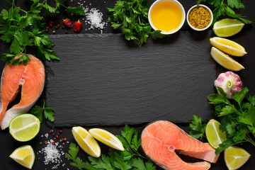 Fresh raw salmon steak And ingredients for preparation around the cutting board. Top view with copy space