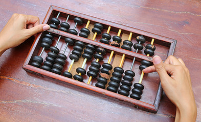 Woman hands holding Chinese ABACUS old antique calculator retro finance education ,tool work business accounting.