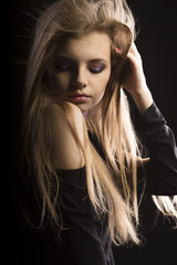 Beautiful young model with lush blonde hair posing at studio