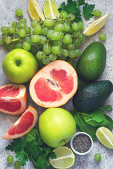 Selection of green vegetables and fruits on a gray concrete background closeup. Detox, dieting, vegetarian, fitness, healthy lifestyle concept.
