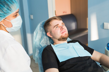 Fototapeta premium Portrait of male. Dental care Concept. Dental inspection is being given to beautiful man surrounded by dentist