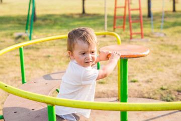 Cute young child boy or kid playing on playground.