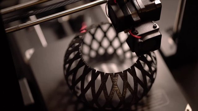 A 3D printer working to create a modern abstract bowl.