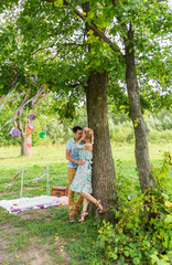 Naklejka na ściany i meble Couple embracing on nature. Young romantic man and woman standing and hugging each other with tenderness outdoors. Young love concept.