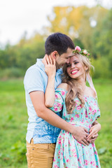 Couple embracing on nature. Portrait of Young romantic man and woman standing and hugging each other with tenderness outdoors. Young love concept.