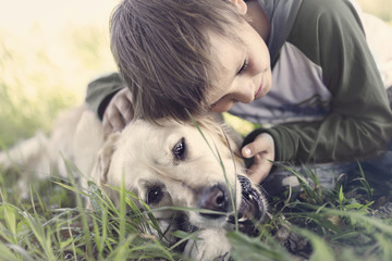 Small boy embracing sweetly his dog