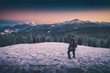 Hiker standing on a hill with snow. Instagram stylization