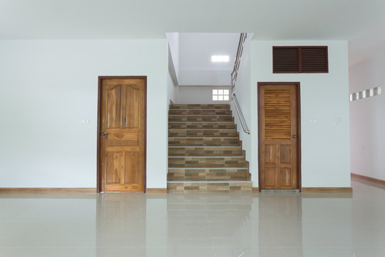 white empty room interior with wooden door and staircase