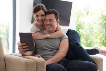 Obraz premium couple relaxing at home with tablet computers