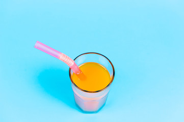 Fresh orange juice on blue background.
