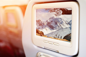 Aircraft monitor in front of passenger seat showing high snow moutain view