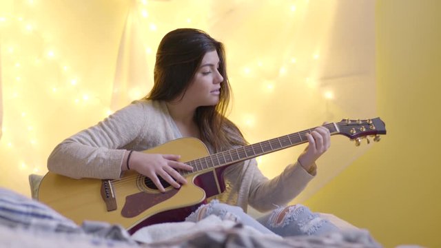 Multiethnic Teen Practices The Guitar In Her Bedroom Or College Dorm