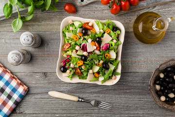 Italian salad with fresh vegetables with black olives and Parmesan cheese.