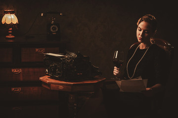 Beautiful young woman reading in retro interior