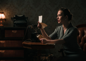 Beautiful woman reading letter in retro interior