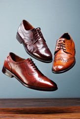Fashion classical polished men's brown oxford brogues shades of brown oxford brogues.Conept flying shoes.Gray background